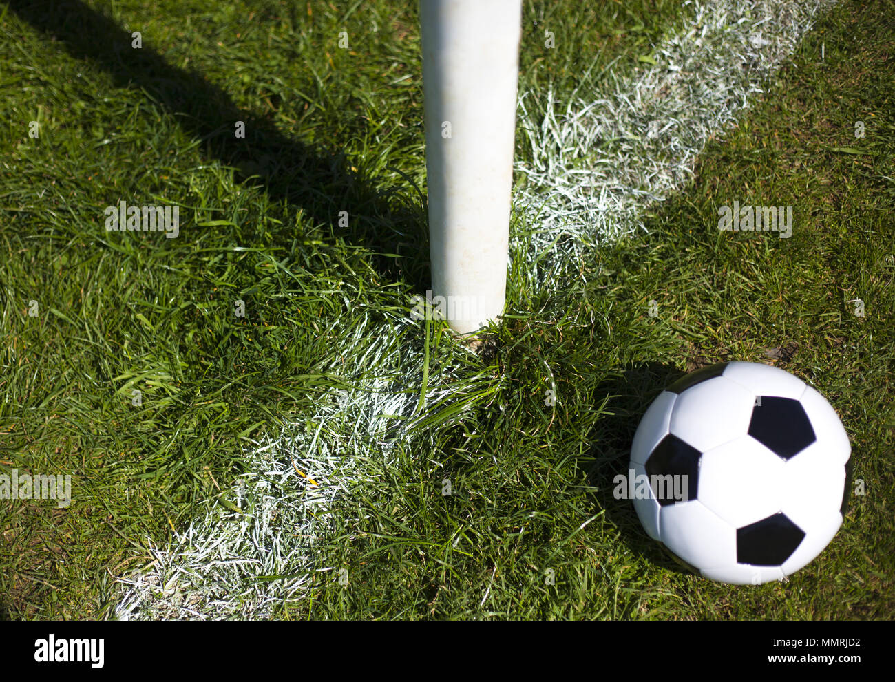 Un cuir noir et blanc football près de un poteau de but et la ligne Banque D'Images