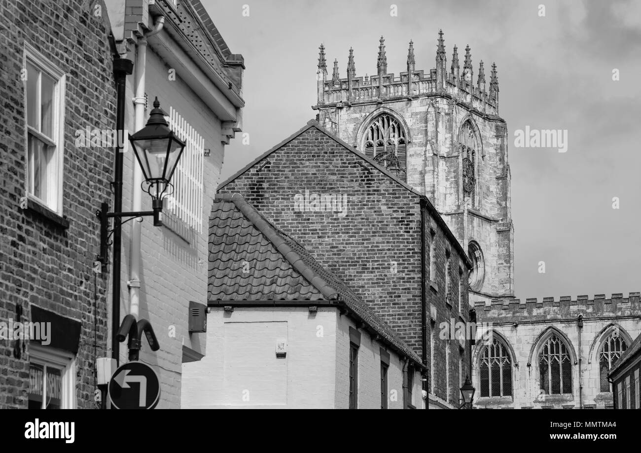 Vue de l'église St Mary et beffroi, vue de l'Ladygate flanquée de bâtiments en brique sur fond de ciel bleu au printemps en Beverley, Yorkshire, UK. Banque D'Images
