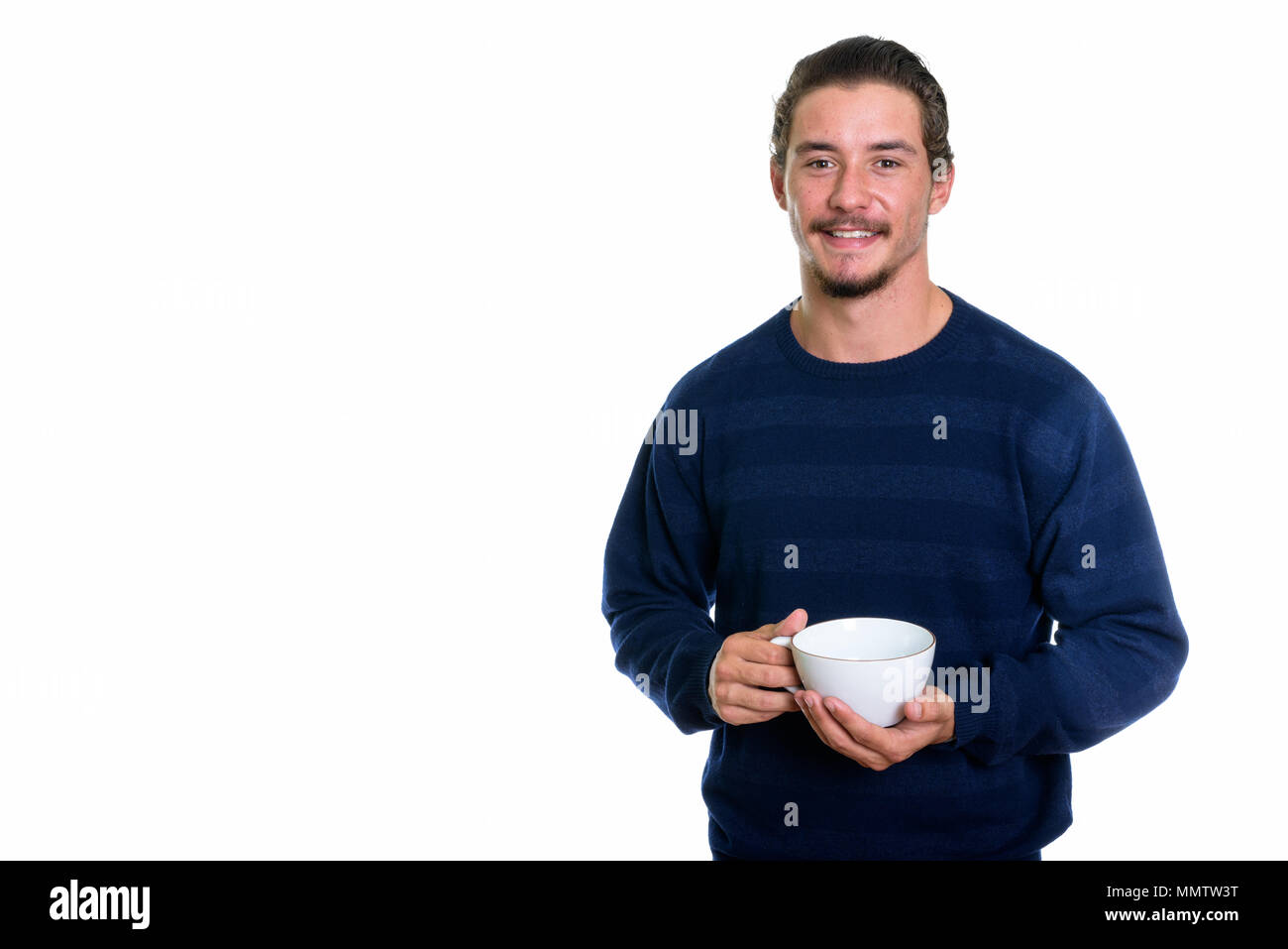 Studio shot of young man smiling while holding Coffee cup Banque D'Images