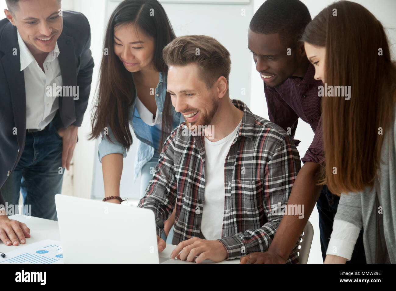Heureux de l'équipe multi-ethnique excité par suite en ligne regardant lapt Banque D'Images