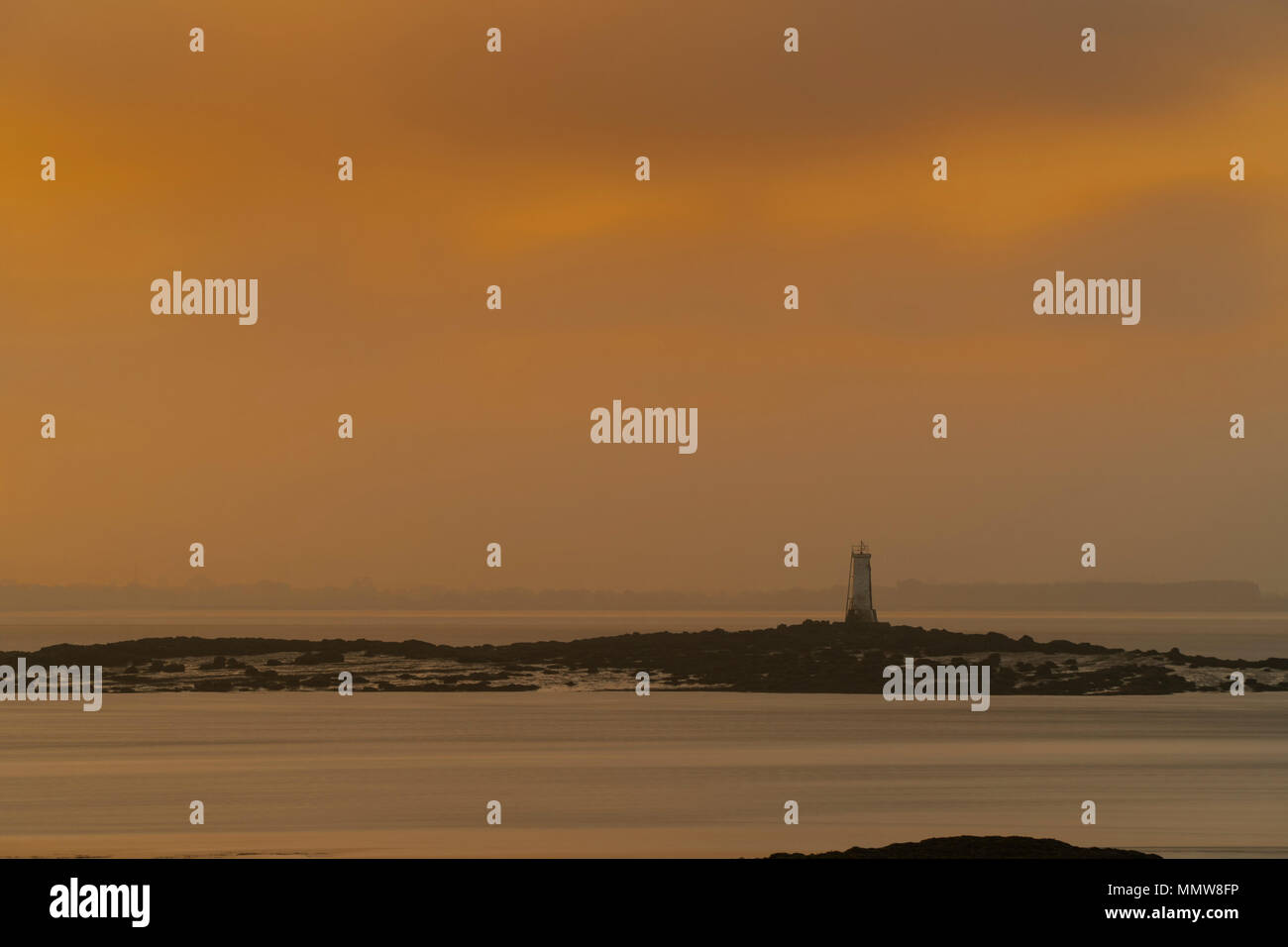 Image de phare au large de la côte prise au lever du soleil. Matin luisent. Lumière, ciel. Banque D'Images