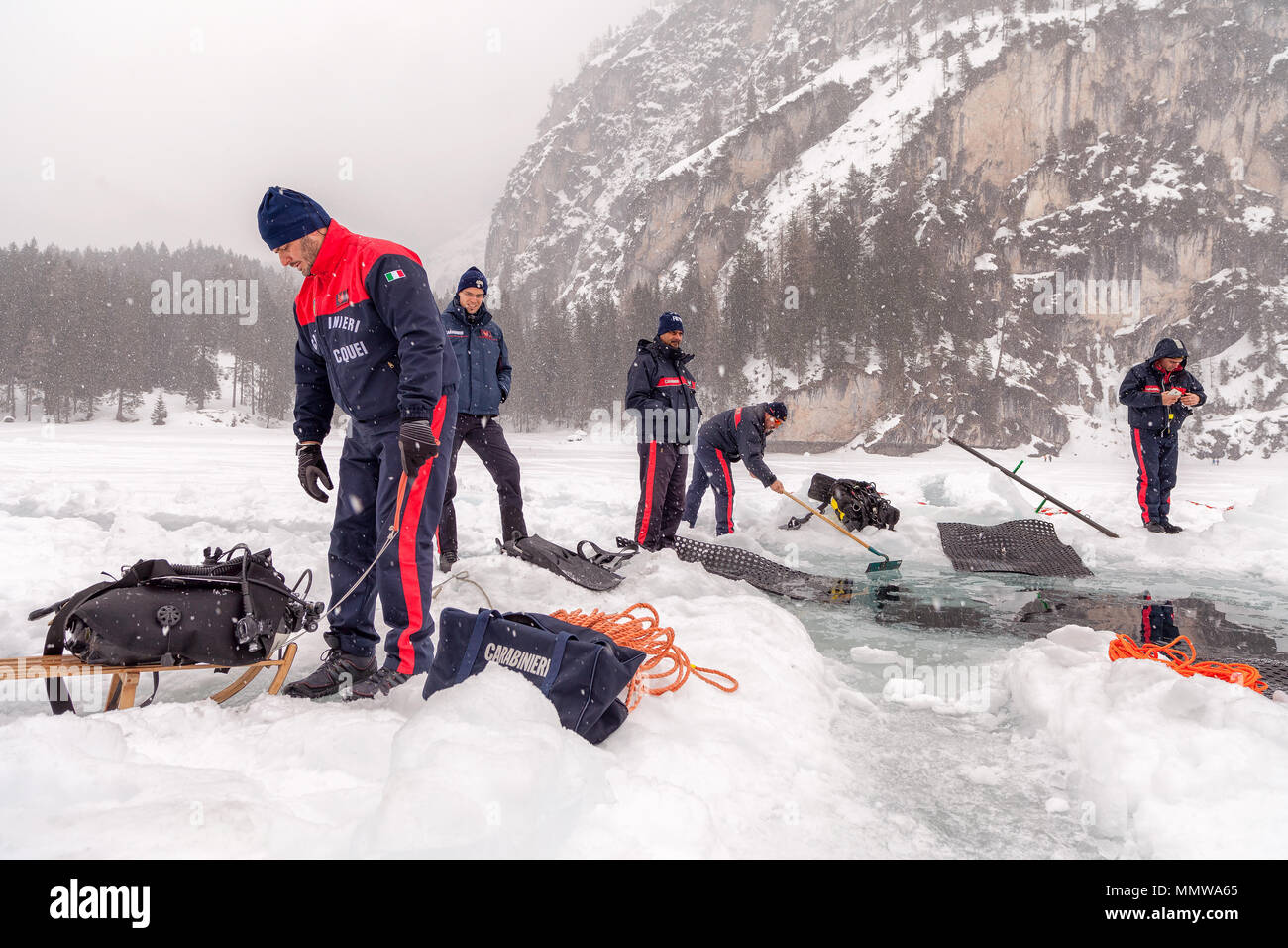 Lac de braies, Italie - Mars 10th, 2018 : Carabinieri italiens creuser un gros trou dans la glace pour laisser entrer les plongeurs de sauvetage dans le lac, Braies, ita Banque D'Images