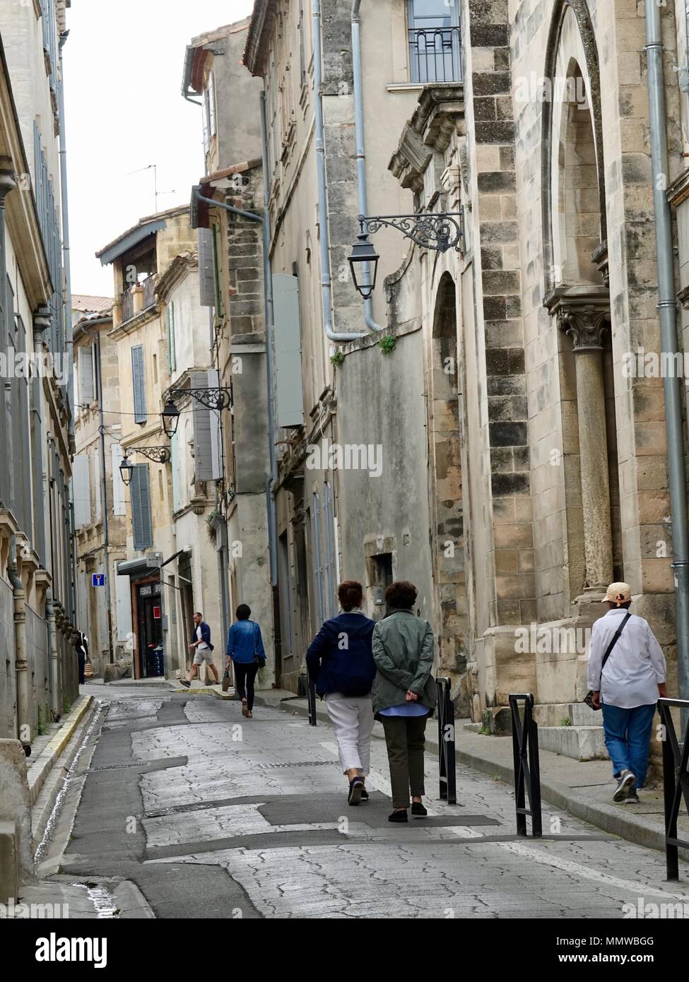 Les gens qui marchent dans une rue étroite dans la vieille ville d'Arles, France Banque D'Images