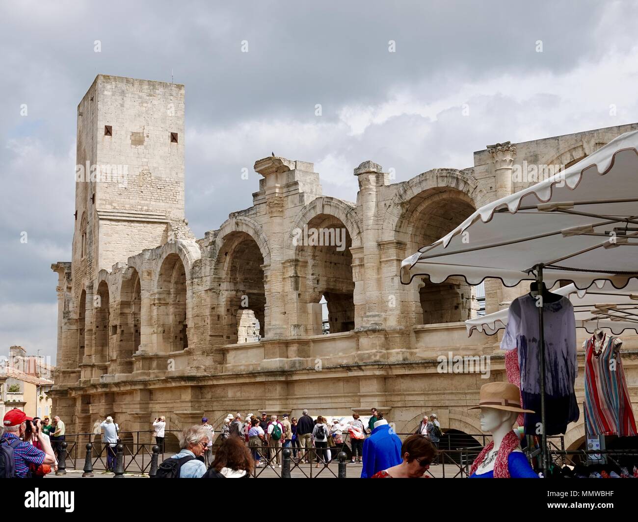 Groupe de touristes matures debout devant l'amphithéâtre romain, Arles, France Banque D'Images