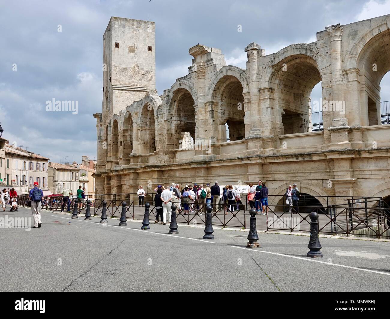Groupe de touristes matures debout devant l'amphithéâtre romain, Arles, France Banque D'Images