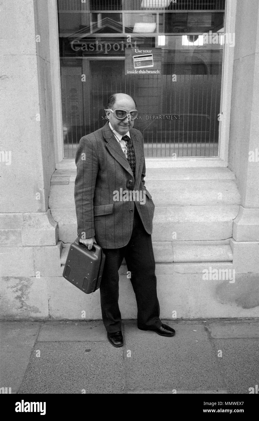 Courrier bancaire livrant de l'argent etc 1970s Royaume-Uni. Un homme de sécurité d'âge moyen qui livre de l'argent dans une caisse à une banque de rue et porte des vêtements de protection, juste des lunettes HOMER SYKES des années 1979 70 Banque D'Images