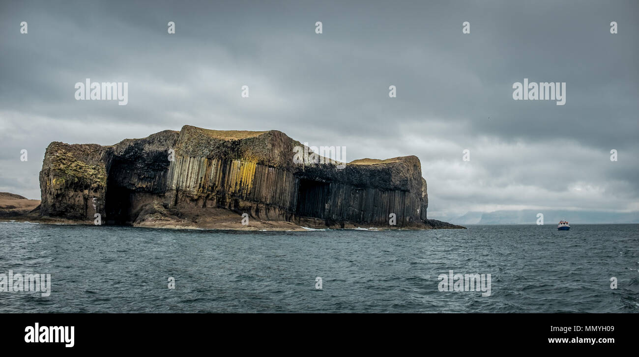 Vue panoramique sur l'île de Staffa et voile au large des côtes écossaises. Banque D'Images