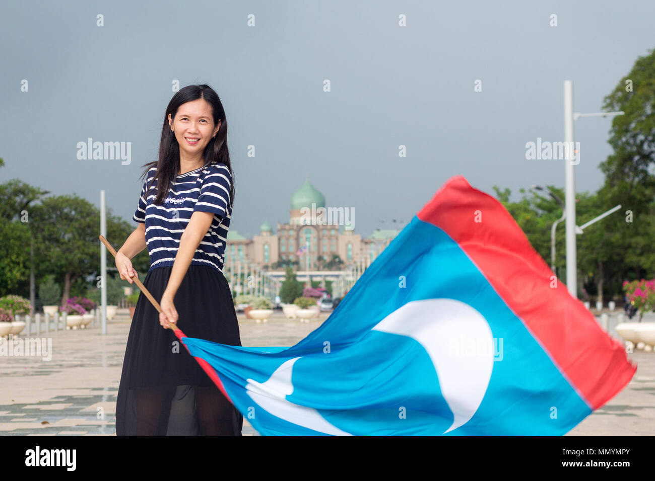 PUTRAJAYA MALAISIE 12 mai 2018 - une supportrice de la partie gagnante de l'élection générale, agiter le drapeau de PKR en face du Premier Ministère Banque D'Images