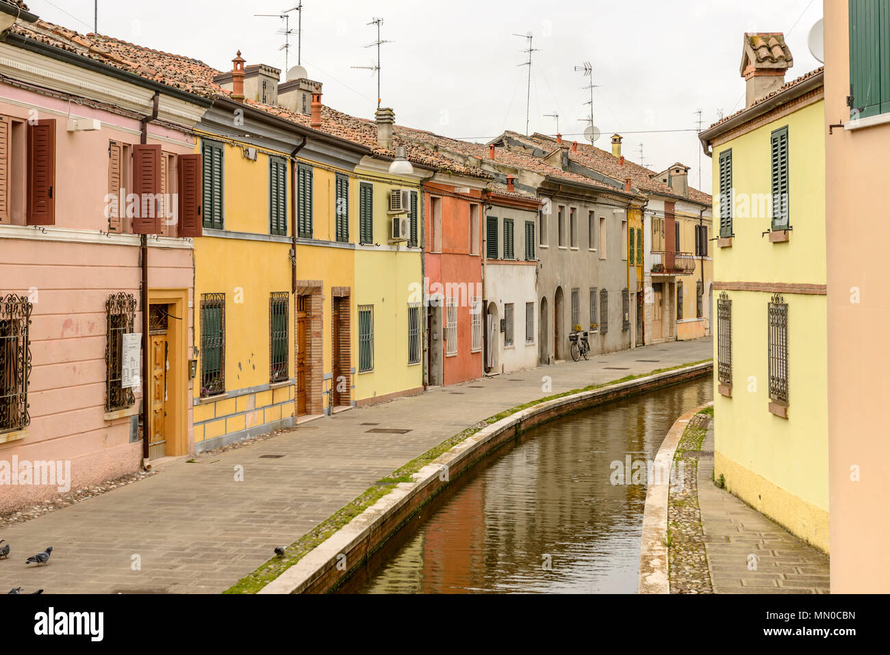 Paysage urbain avec de vieilles maisons sur le quai près du canal de flexion dans la rue Buonafede, tourné en lumière vive à Comacchio, Ferrara, Italie Banque D'Images