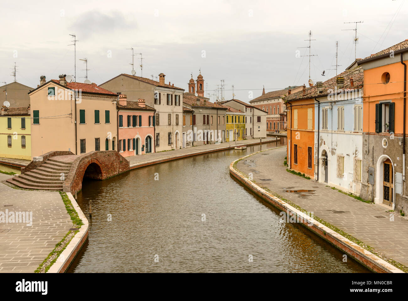 Paysage urbain de maisons anciennes sur les endiguements et Sisti ancien pont, tourné en lumière vive à Comacchio, Ferrara, Italie Banque D'Images