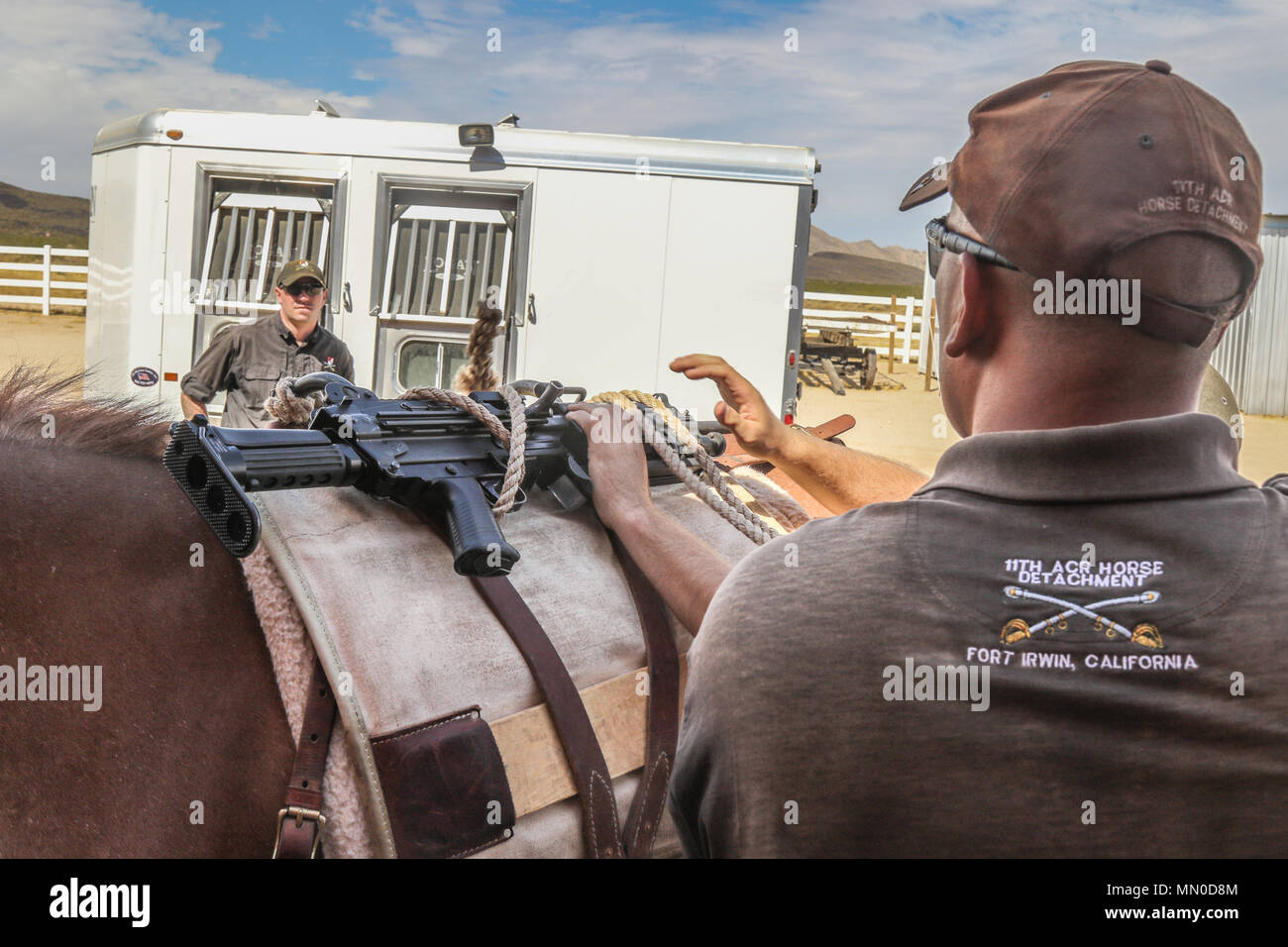 FORT IRWIN, en Californie - Des soldats du détachement de cheval, l'Escadron de soutien régimentaire, 11e Régiment de cavalerie blindée, et Bronco 71 opérations de l'équipe, Groupe, Centre National de Formation, fixer une mitrailleuse M240B à une mule de selle pendant la formation, d'emballage, 1 août 2017. Bronco 71 fonctionne avec les membres de l'Équipe des affaires civiles, les opérations psychologiques, les opérations d'information et de formateurs. (U.S. Photo de l'armée par le Sgt. David Edge, 11e) de l'ACR Banque D'Images