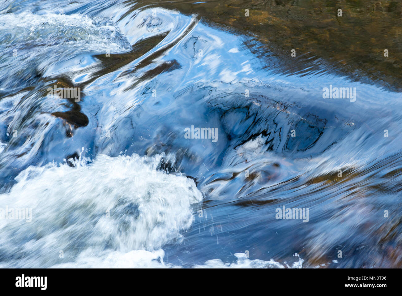 L'eau dans une rivière et se précipiter sur les rochers, tourbillonnant, au calme d'un côté et turbulent de l'autre. Banque D'Images