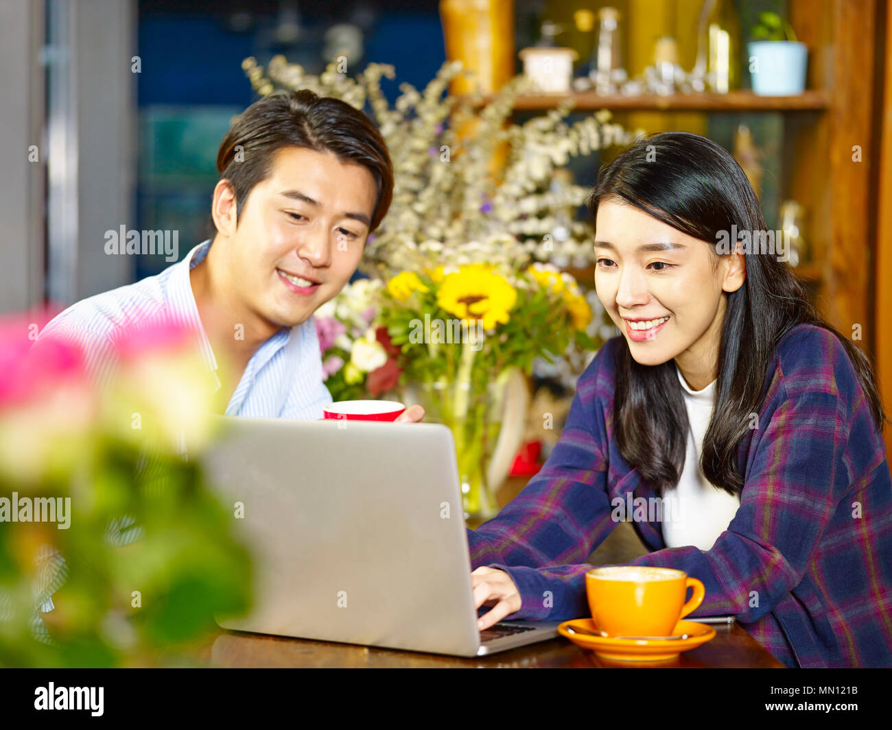 Happy young asian woman using laptop computer in coffee shop Banque D'Images