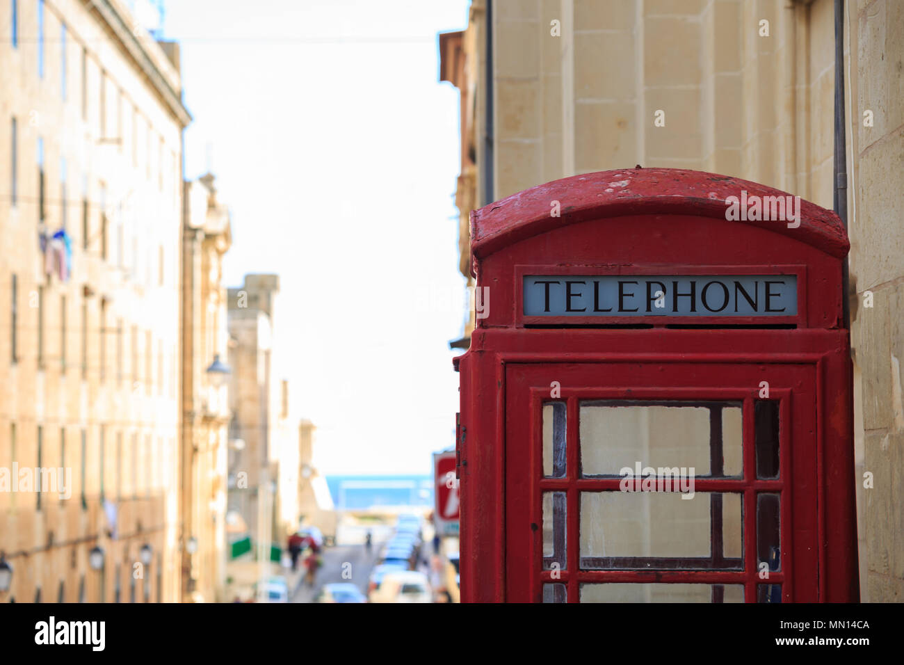 La cabine téléphonique rouge traditionnel. Blanc, vieux, pelée phone box à La Valette, Malte. L'espace pour le texte, voir la ville, de troubles de l'arrière-plan. Banque D'Images