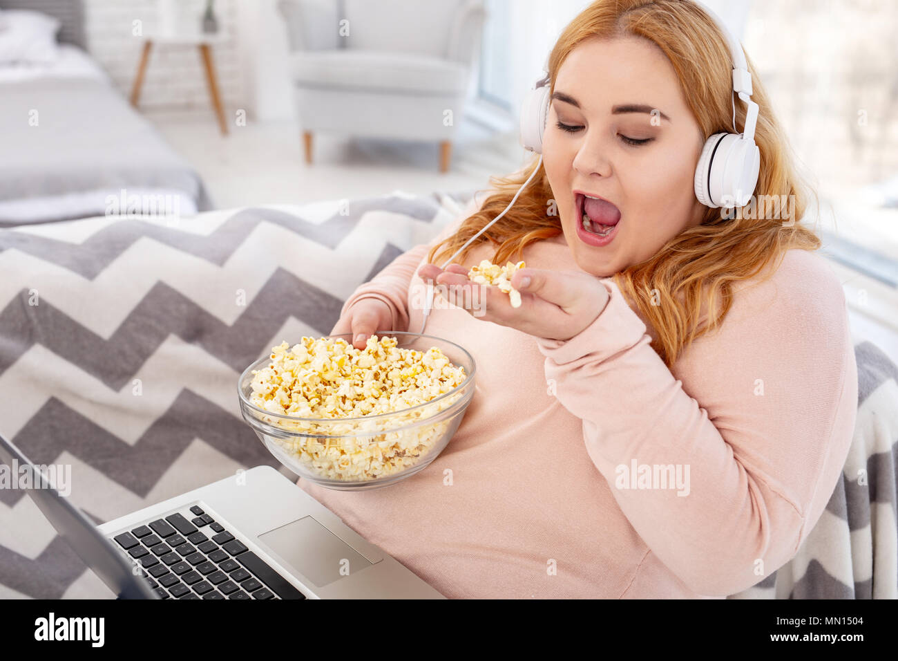 Heureux l'embonpoint femme regardant un film Banque D'Images