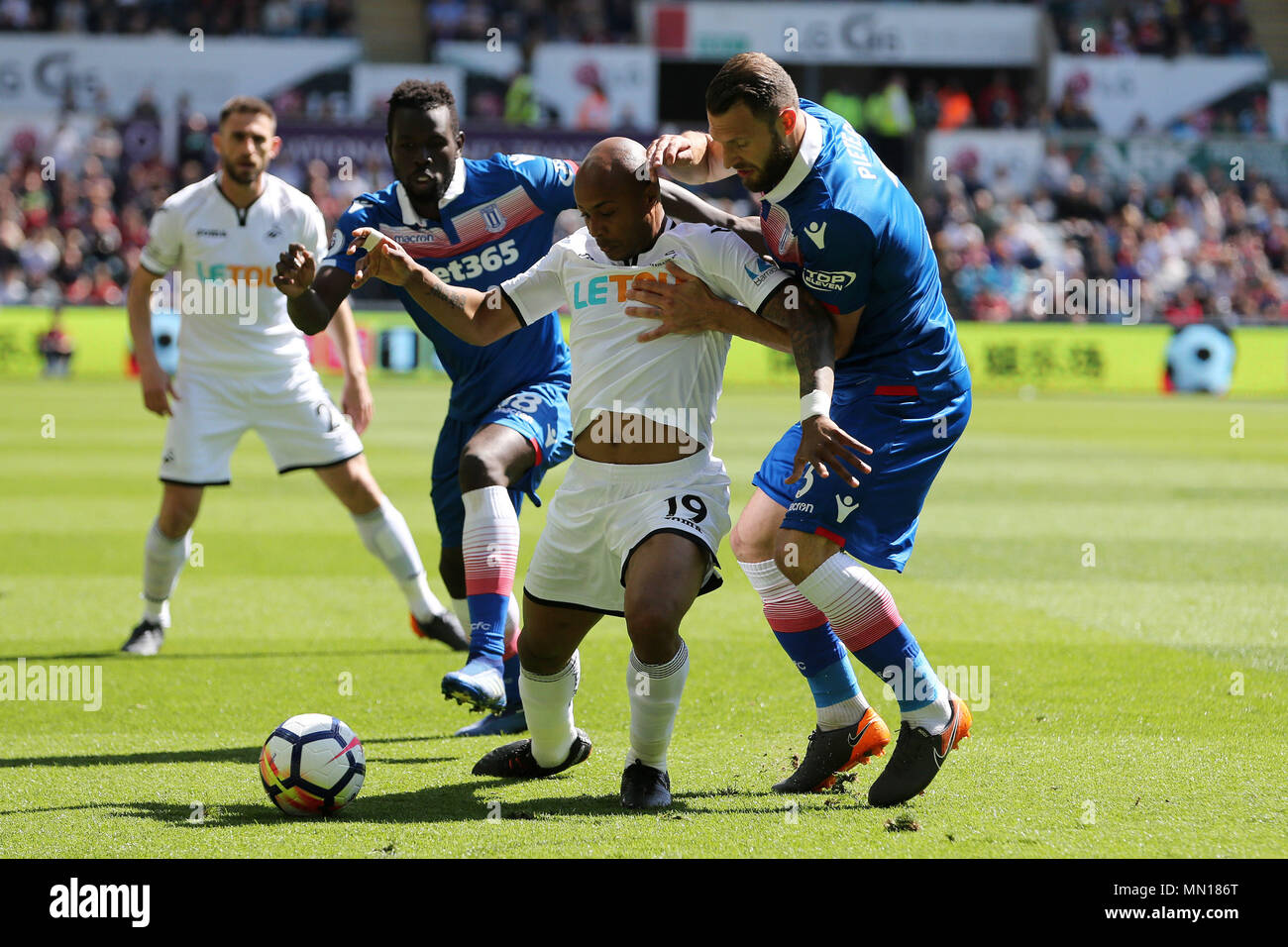 Swansea, Pays de Galles, Royaume-Uni. 13 mai, 2018. Swansea, Royaume-Uni. 13 mai, 2018. Andre Ayew de Swansea City © est abordé par Stoke City's Erik Pieters ¨ et Mame Biram Diouf. Premier League, Swansea City v Stoke City au Liberty Stadium de Swansea, Pays de Galles du Sud le dimanche 13 mai 2018. Cette image ne peut être utilisé qu'à des fins rédactionnelles. Usage éditorial uniquement, licence requise pour un usage commercial. Aucune utilisation de pari, de jeux ou d'un seul club/ligue/dvd publications. Photos par Andrew Andrew/Verger Verger la photographie de sport/Alamy live news Crédit : Andrew Orchard la photographie de sport/Alamy Live News Banque D'Images