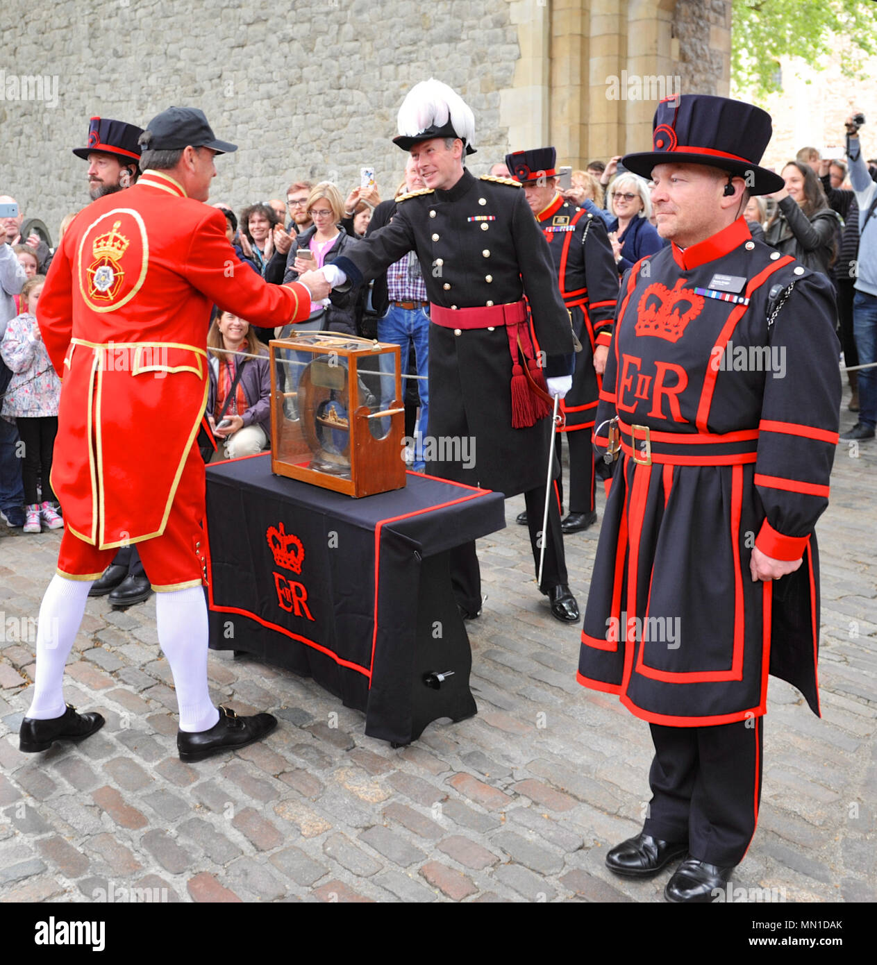 Londres, Royaume-Uni. 13 mai, 2018. La stèle est présenté à James Murly-Gotto (Devoir Gouverneur de HM Tour de Londres, l'uniforme sombre) par HM Barge (uniforme rouge) et les membres de la compagnie de mariniers et Aconiers. La stèle est un morceau de tuyau d'eau médiéval fabriqué à partir d'un tronc d'arbre creux. Il est offert chaque année pour le gouverneur de la tour (pour plus de sécurité) par les membres de l'entreprise de mariniers et Aconiers ligne qui l'imprimeur de la barge, Gloriana', 'l'exécution la stèle, Palais de Hampton Court à la tour le long de la Tamise. Crédit : Michael Preston/Alamy Live News Banque D'Images