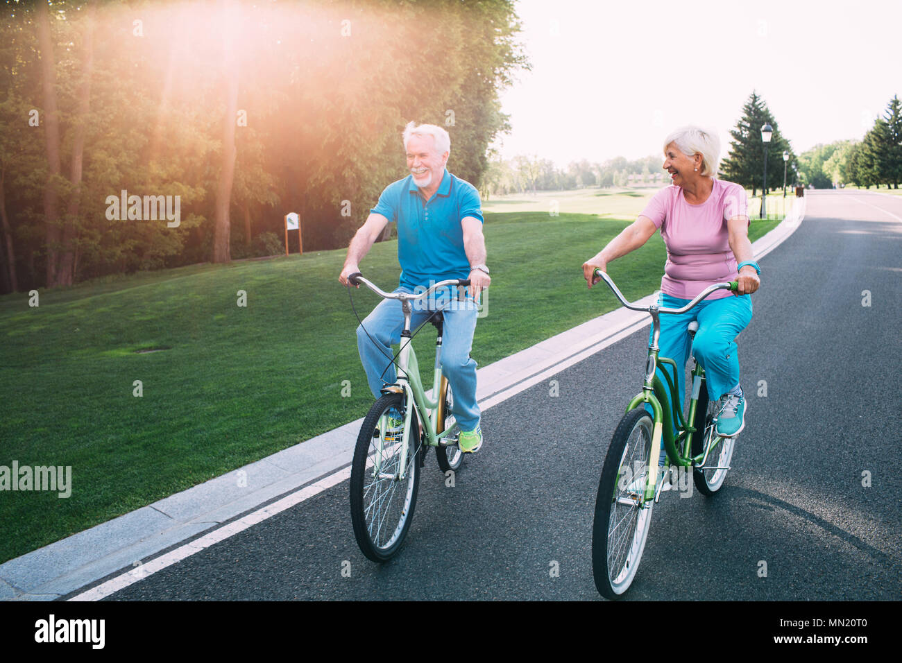 D'âge mûr de la bicyclette sur parc. Une femme et un homme âgés participent activement à la retraite, au repos Banque D'Images