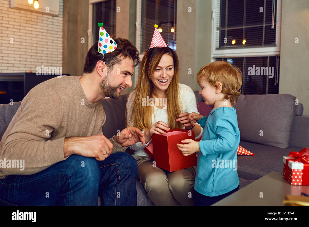 Les parents donnent un cadeau à leur enfant le jour de naissance. Banque D'Images