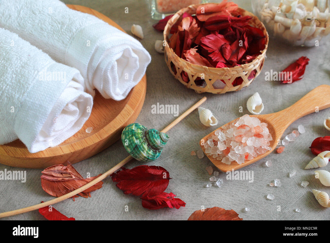 Close up de l'himalaya sels sur cuillère en bois ensemble spa décorer avec des fleurs rose à sec Banque D'Images