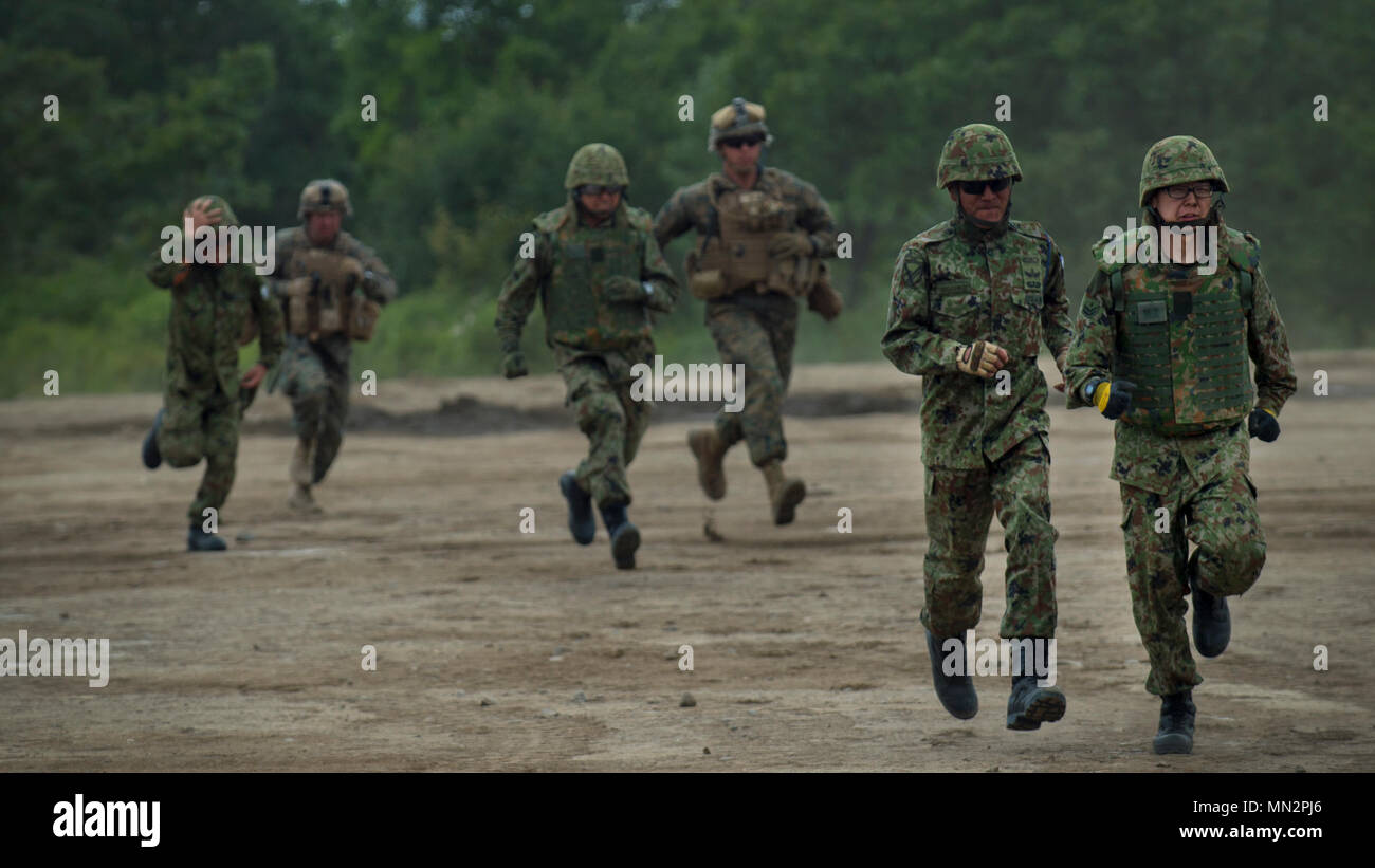 La masse des membres de la Force d'autodéfense du Japon à sprint après leur vol de familiarisation du MV-22 Osprey Viper 17 au cours de la journée des médias du Nord d'Hokkaido, Japon, le 18 août 2017. Misawa Air Base a été une plaque tournante pour le personnel maritime des États-Unis et d'aéronefs, l'exercice de la capacité de l'équipe de Misawa à prospérer grâce à un afflux d'autres membres du service. Divers organismes sont regroupés pour assurer la Marines des États-Unis ont l'équipement et de l'appui pour soutenir des activités de formation. (U.S. Photo de l'Armée de l'air par le sergent. Deana Heitzman) Banque D'Images