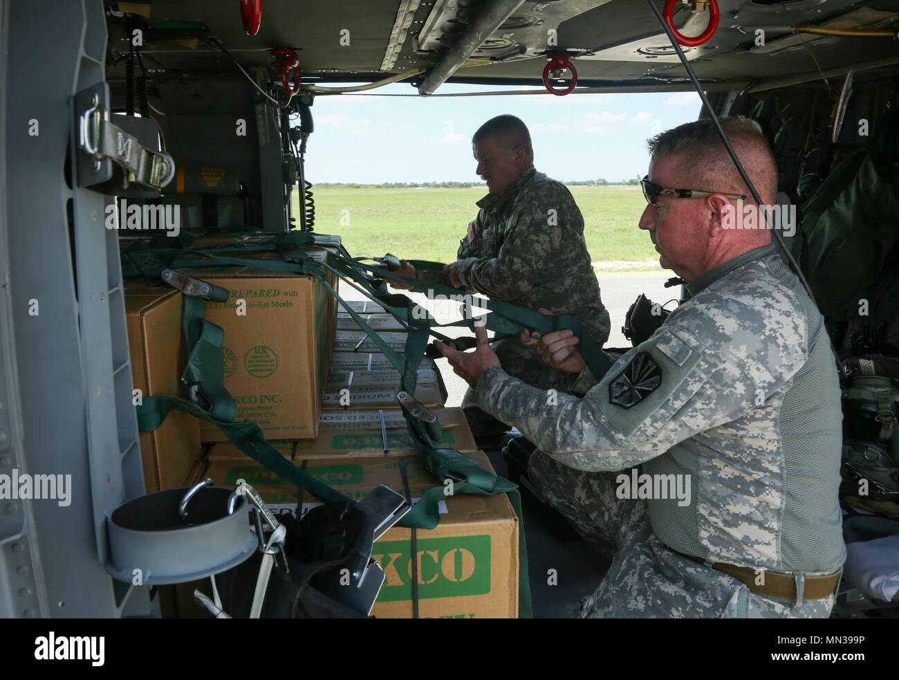 Le sergent de l'armée américaine. Daniel Carnahan (avant) et le sergent. 2 Tym Larson, le détachement, l'entreprise de Golf, 2e Bataillon, 238e Régiment, membres de l'équipe d'un UH-60 Blackhawk', 'sangle vers le bas, du fret, de l'aérodrome d'artillerie Seguin Tx., 30 août 2017. Cet équipage est en Meals-Ready-à-manger à ceux qui sont touchés par l'ouragan Harvey. (U.S. Photo de l'armée par la FPC. Joseph Cannon) Banque D'Images