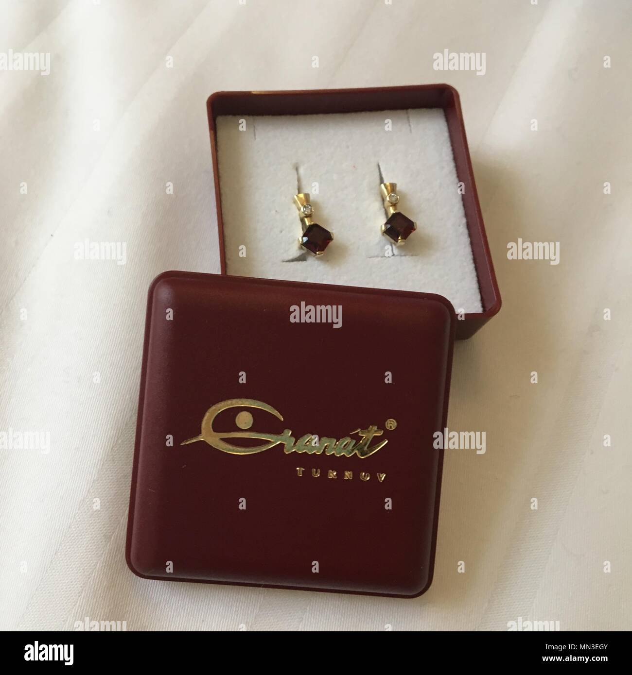 Boucles d'oreille grenat assis dans une boîte à bijoux bourgogne les mots d'or Granat la Turquie. Banque D'Images