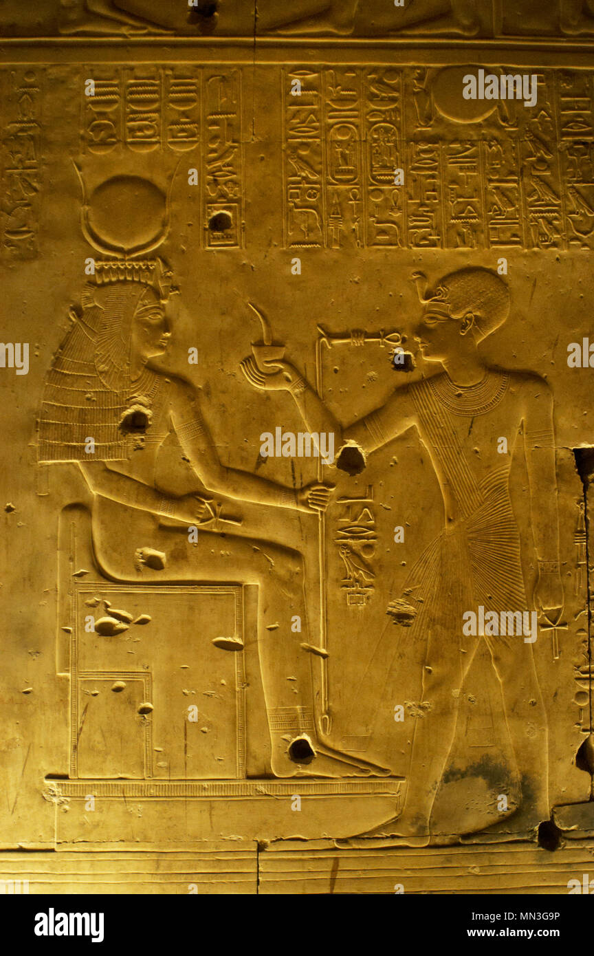 L'Égypte. Abydos. Temple de Seti I. nouveau royaume. 19e dynastie. Soulagement avec polychrome d'origine. Le Pharaon en faisant des offrandes à la déesse Isis. 1292-1189 BC. Banque D'Images