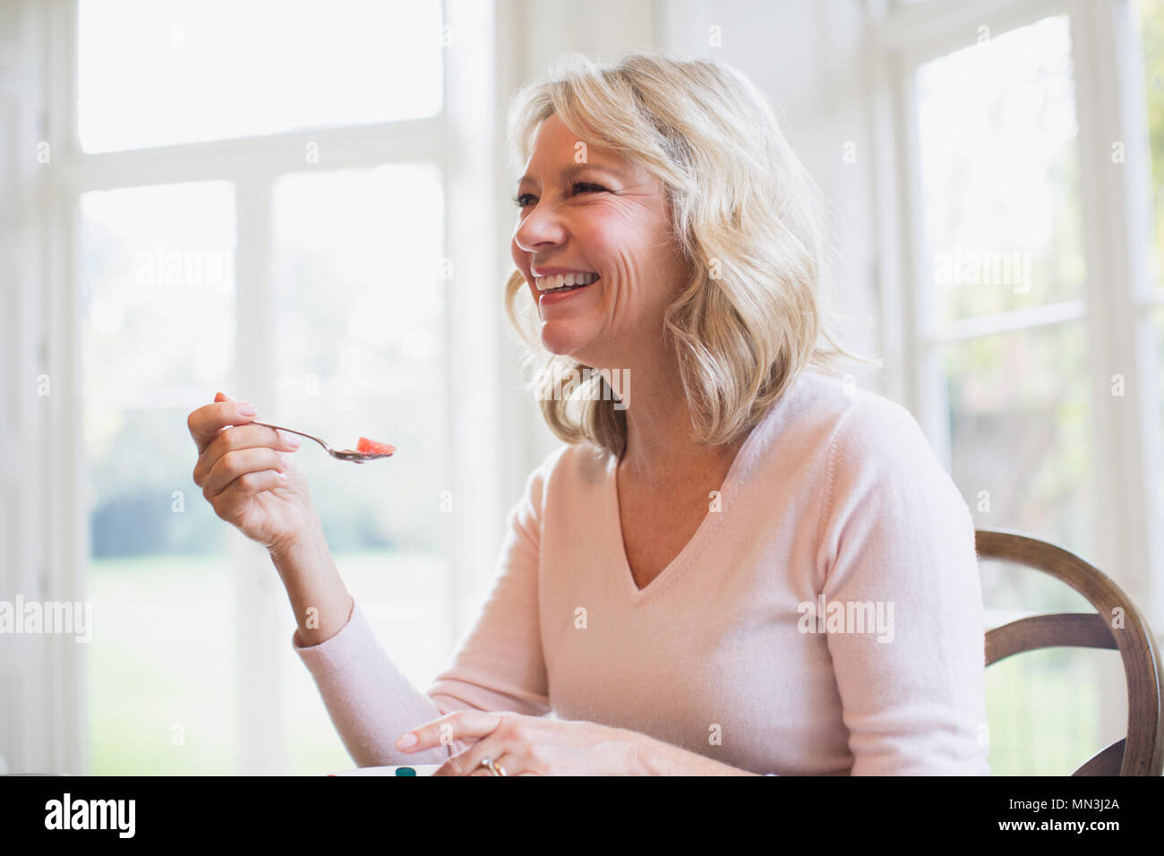 Happy young woman eating fruit Banque D'Images