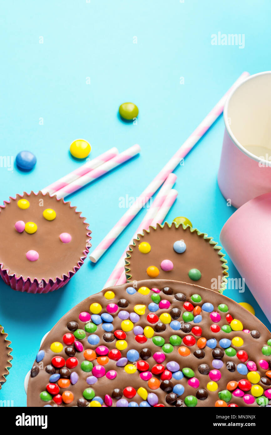 Gâteau d'Anniversaire Chocolat au lait avec vitrage multicolore Candy Sprinkles  renoncules Gobelets pailles papier rose fond bleu. Célébration parti Ki  Photo Stock - Alamy