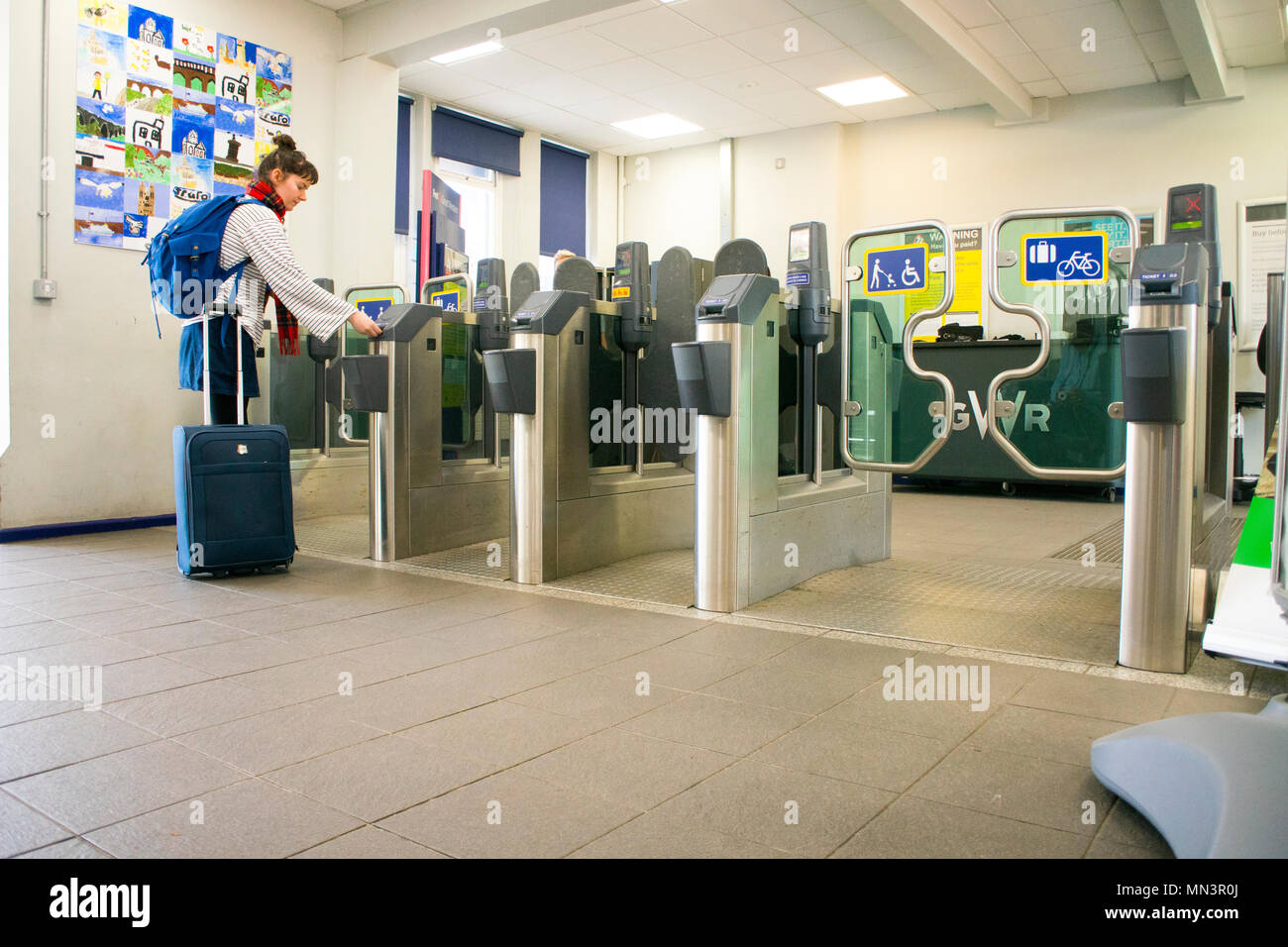 Femelle adulte présentant un billet à une gare ferroviaire - barrière John Gollop Banque D'Images