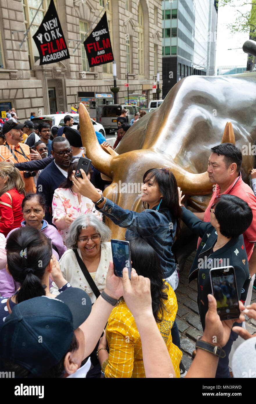 Des foules de touristes prenant des photos autour du Wall street bull, Bull ou de charge, par Arturo di Modica, le centre-ville de New York City, USA Banque D'Images