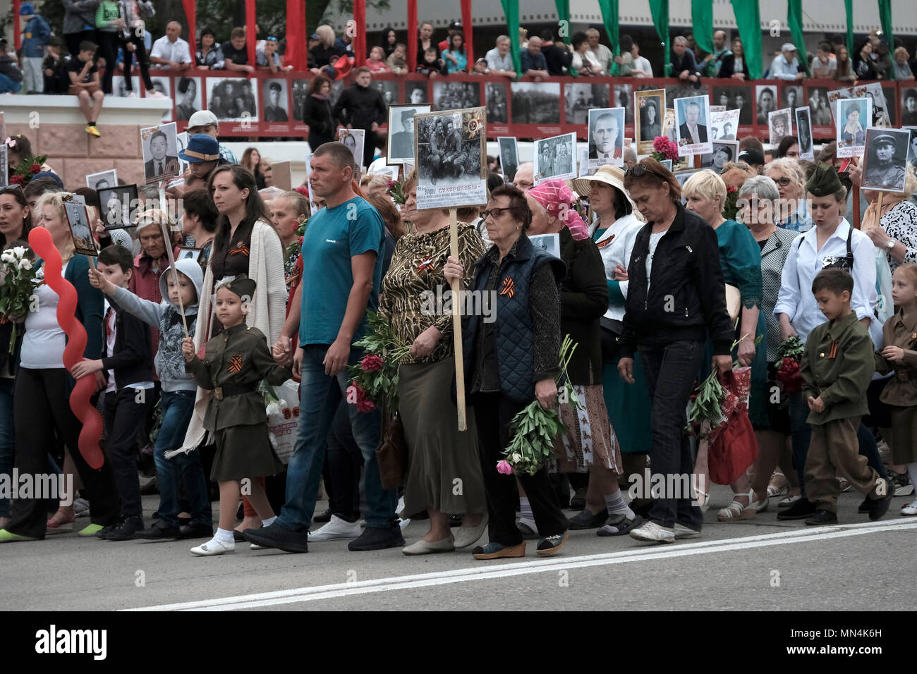 Les civils transnistriens portent des portraits de leurs ancêtres et des participants à la seconde Guerre mondiale pendant le jour de la victoire le 9 mai qui commémore la victoire de l'Union soviétique sur l'Allemagne nazie dans la rue du 25 octobre dans le centre de Tiraspol la capitale de Pridnestrovie, officiellement connue sous le nom de République moldave Pridnestrovienne PMR et également appelée Transnistrie depuis 1992 un État sécessionnaire enclavé internationalement reconnu comme faisant partie de la Moldavie Banque D'Images