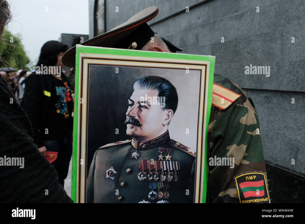 Un membre des forces armées de la République moldave Pridnestrovienne tient une photo de Staline pendant le jour de la victoire le 9 mai qui commémore la victoire de l'Union soviétique sur l'Allemagne nazie dans le centre de Tiraspol la capitale de Pridnestrovie, officiellement connue sous le nom de République moldave Pridnestrovienne PMR et également appelée Transnistrie depuis 1992 un Etat sécessionniste enclavé internationalement reconnu comme faisant partie de la Moldavie Banque D'Images