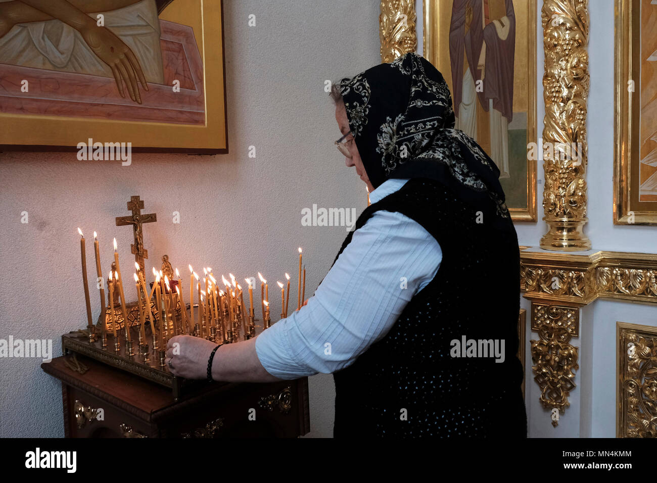 Une femme allume des bougies à l'intérieur de la chapelle orthodoxe de Saint-Georges au Mémorial de la gloire qui commémore les morts de la guerre de Transnistrie de 1990-1992 situé sur la place Suvorov à Tiraspol, la capitale de Pridnestrovie, officiellement connue sous le nom de République moldave Pridnestrovienne PMR et également appelée Transnistrie depuis 1992 un État sécessionniste enclavé internationalement reconnu comme faisant partie de la Moldavie Banque D'Images