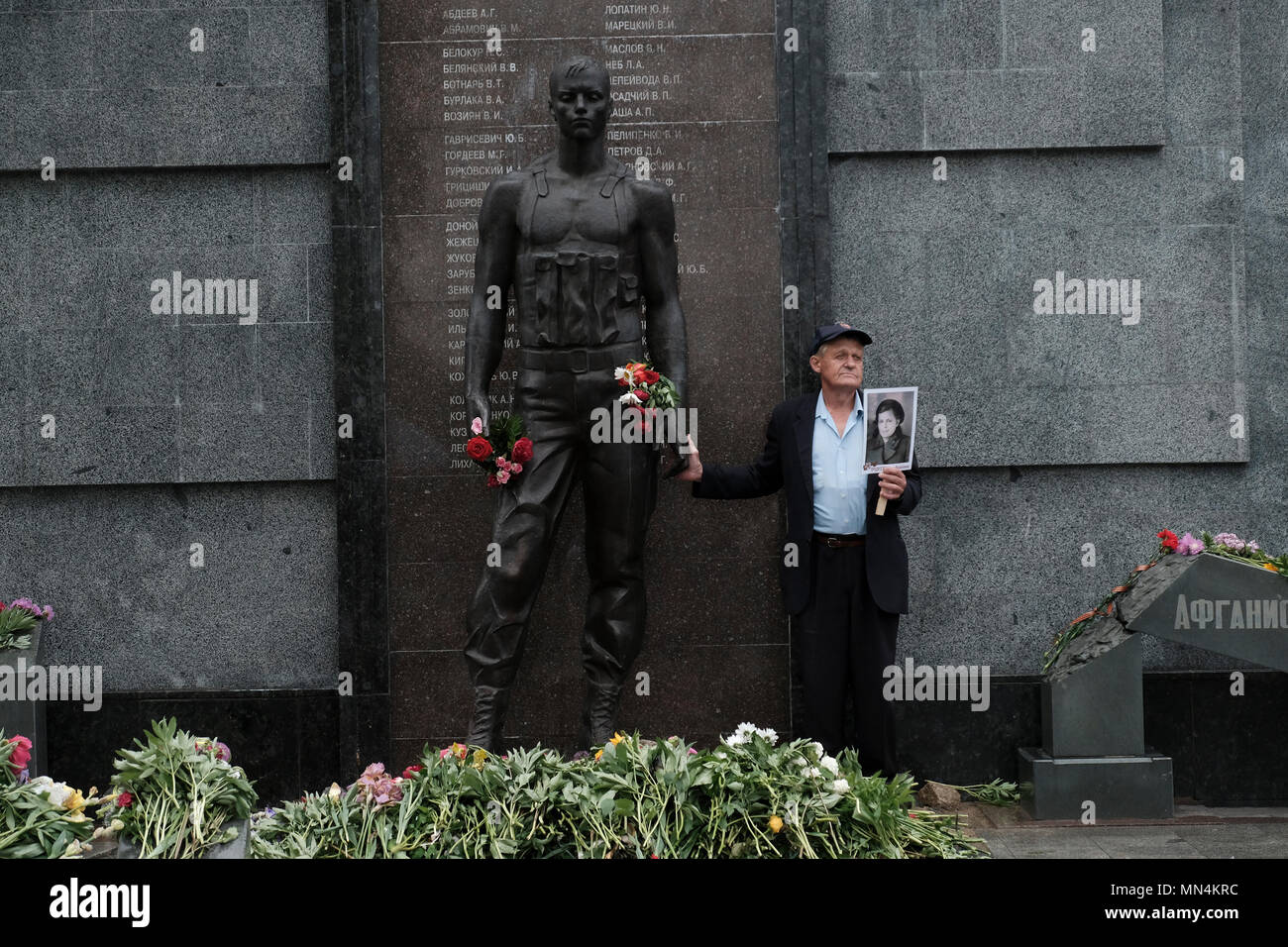 Un homme tient une photo d'une personne qui a combattu pendant la seconde Guerre mondiale pendant le jour de la victoire le 9 mai qui commémore la victoire de l'Union soviétique sur l'Allemagne nazie dans le Mémorial de la gloire qui commémore les vétérans et les morts de la seconde Guerre mondiale, la guerre soviéto-afghane, et la guerre de Transnistrie de 1990-1992 située sur la place Suvorov à Tiraspol, la capitale de Pridnestrovie, officiellement connue sous le nom de République moldave Pridnestrovienne PMR et également appelée Transnistrie depuis 1992 un État sécessionniste enclavé internationalement reconnu comme faisant partie de la Moldavie Banque D'Images