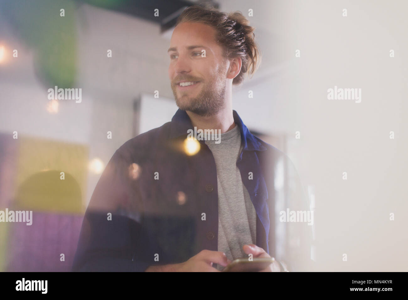 Smiling man texting with smart phone Banque D'Images