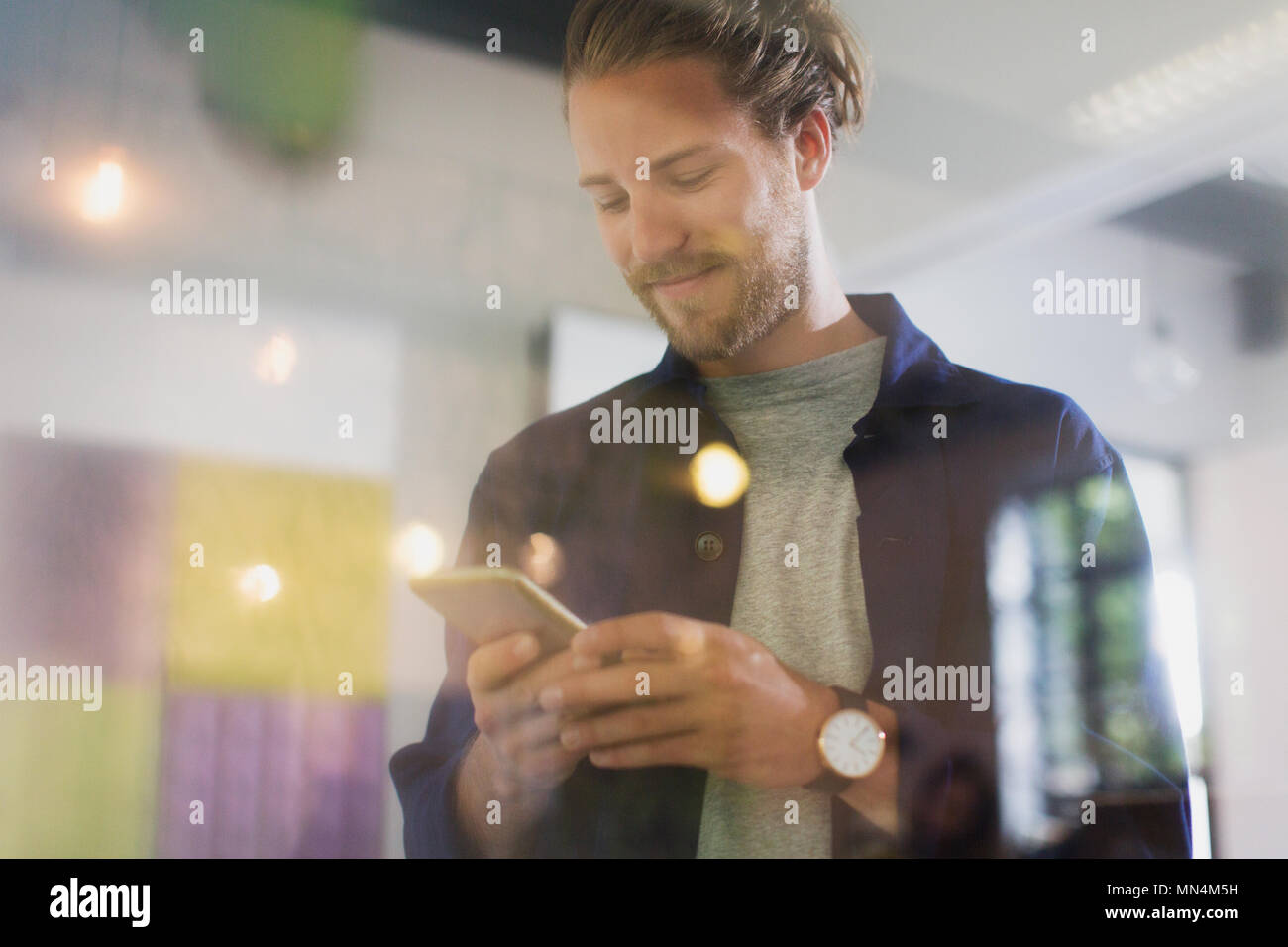 Smiling businessman texting with smart phone Banque D'Images