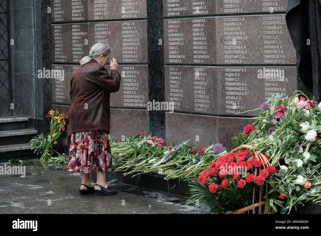Une femme âgée de Transnistrie debout devant le Mémorial de la gloire un monument en plusieurs parties commémorant les anciens combattants et les morts de la Grande Guerre patriotique (seconde Guerre mondiale), de la guerre soviéto-afghane et de la guerre de Transnistrie de 1990-1992 situé sur la place Suvorov à Tiraspol, la capitale de Pridnestrovie, officiellement connue sous le nom de République moldave Pridnestrovienne et également appelée Transnistrie depuis 1992 un État sécessionnaire enclavé internationalement reconnu comme faisant partie de Moldave depuis la Moldave Banque D'Images