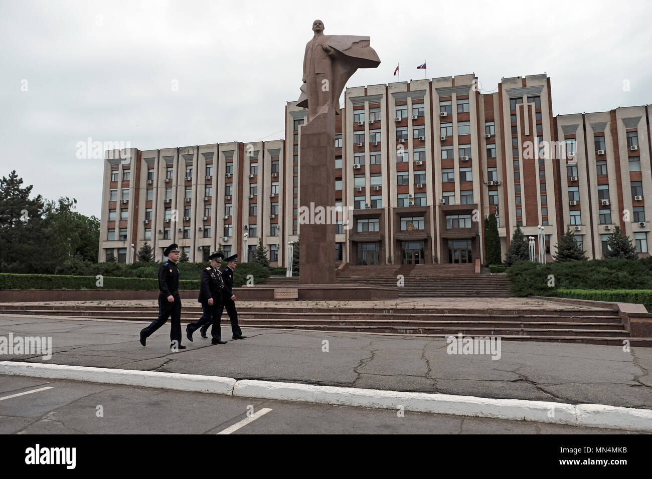 Les officiers des forces armées de la République moldave Pridnestrovienne de l'état semi-reconnu de Transnistrie passent devant la statue de Vladimir Lénine devant le bâtiment du parlement dans le centre de Tiraspol, la capitale de Pridnestrovie, officiellement connue sous le nom de République moldave Pridnestrovienne PMR et également appelée Transnistrie depuis 1992 un état sécessionnaire enclavé internationalement reconnu comme faisant partie de la Moldavie Banque D'Images