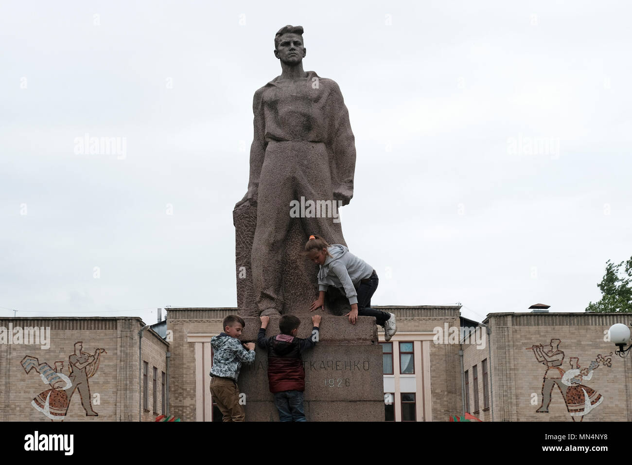 Les enfants gravissent le monument de l'ère soviétique de Pavel Tkachenko qui était un révolutionnaire communiste devant un centre culturel de l'ère soviétique dans la ville de Bender de facto nom officiel Bendery à Pridnestrovie, officiellement connu sous le nom de République moldave Pridnestrovienne PMR et également appelé Transnistrie depuis 1992 un État sécessionniste enclavé internationalement reconnu comme faisant partie de la Moldavie Banque D'Images