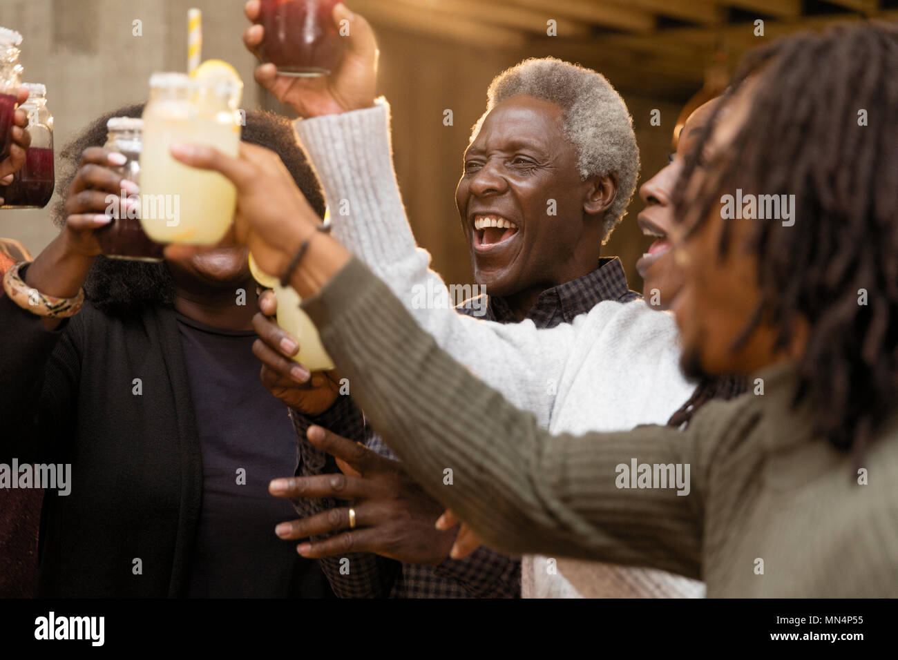 Heureux, enthousiaste multi-generation family toasting limonade et sangria Banque D'Images