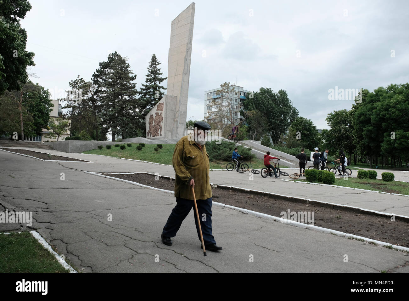 Un homme âgé passe devant un monument de l'ère soviétique commémorant le 50e anniversaire de l'insurrection de Bender, un soulèvement armé de 1919 par les bolcheviks contre la Bessarabie et la Roumanie dans la ville de Bender de facto nom officiel Bendery à Pridnestrovie, officiellement connu sous le nom de République moldave Pridnestrovienne PMR et également appelé Transnistrie depuis 1992 un État sécessionniste enclavé internationalement reconnu comme faisant partie de la Moldavie Banque D'Images
