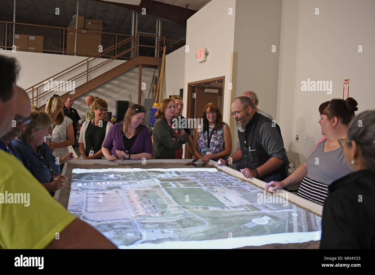 Guernesey Camp agent antiterroriste Lowther montre les enseignants d'art des routes et des voies alternatives pour le Centre de simulation sur une table de sable carte pendant un exercice de simulation le 24 août au Centre de la carte Sim sur Camp Guernesey JTC. Le plan comprend un circuit d'autobus et de chemins de randonnée. La Garde nationale du Wyoming (photo par le Sgt. 1re classe Jimmy McGuire) Banque D'Images