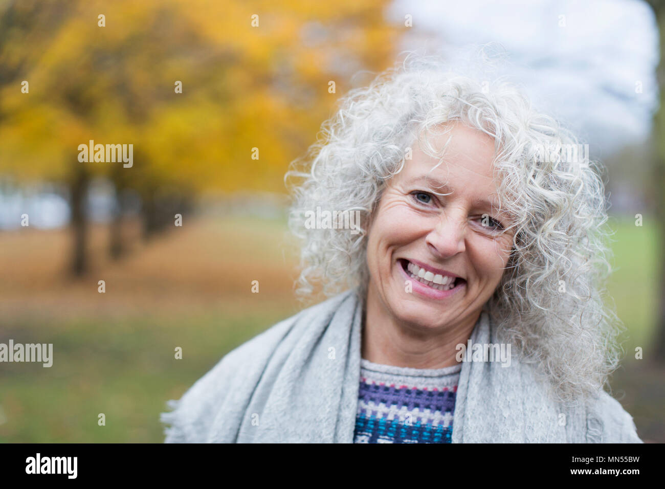 Portrait of smiling senior woman in autumn park Banque D'Images