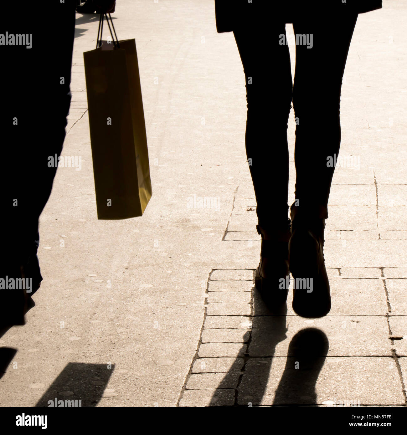 Deux personnes sur les jambes à contraste élevé trottoir ville sépia Banque D'Images