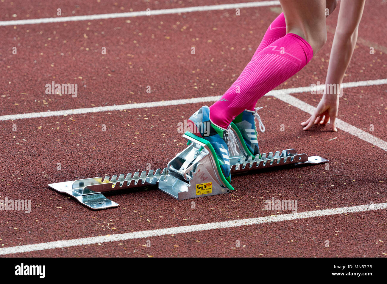 Teenage girl using blocs au départ d'une course, dans le Warwickshire County d'athlétisme, Nuneaton, Royaume-Uni Banque D'Images