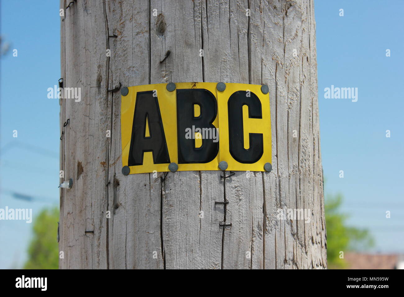 La capitale des lettres a, b, et c sont poinçonnées sur des plaques de métal et de bois cloué à un poteau. Banque D'Images