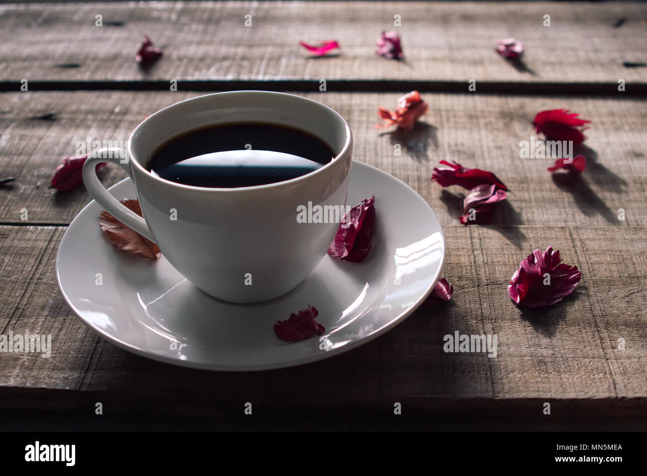 Tasse de café blanc décorer avec rose rouge sur la plaque de bois sec,vintage concept. Banque D'Images