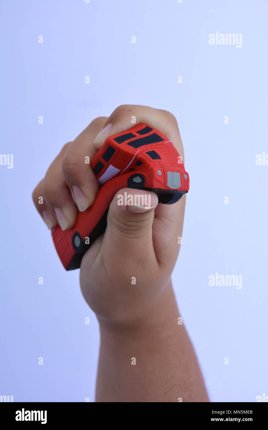 Woman squeezing red bus stress en forme, Close up contre un fond uni avec copie espace. Banque D'Images